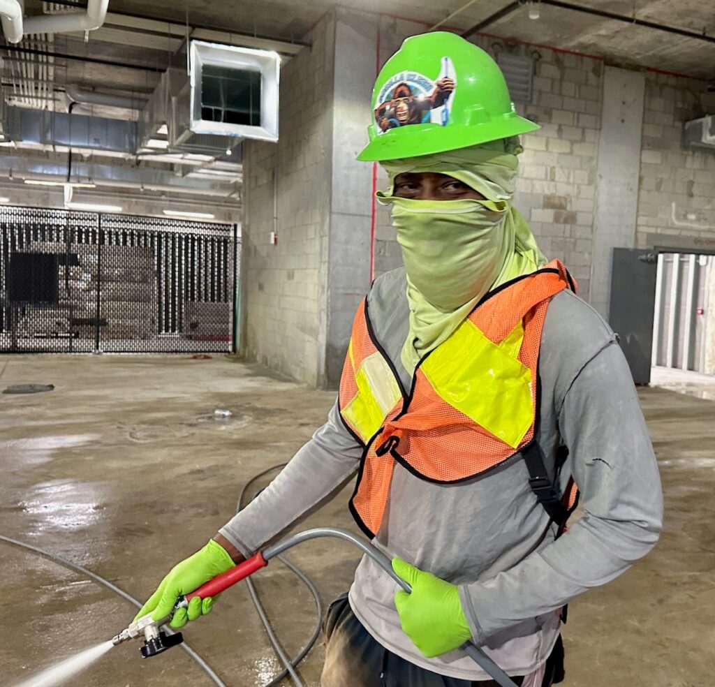 contractor holding a high powered pressure washing gun 